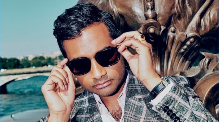Actor Aziz Ansari wears a Gucci suit with a Berluti shirt. He also sports a Rolex watch and Saint Laurent sunglasses.