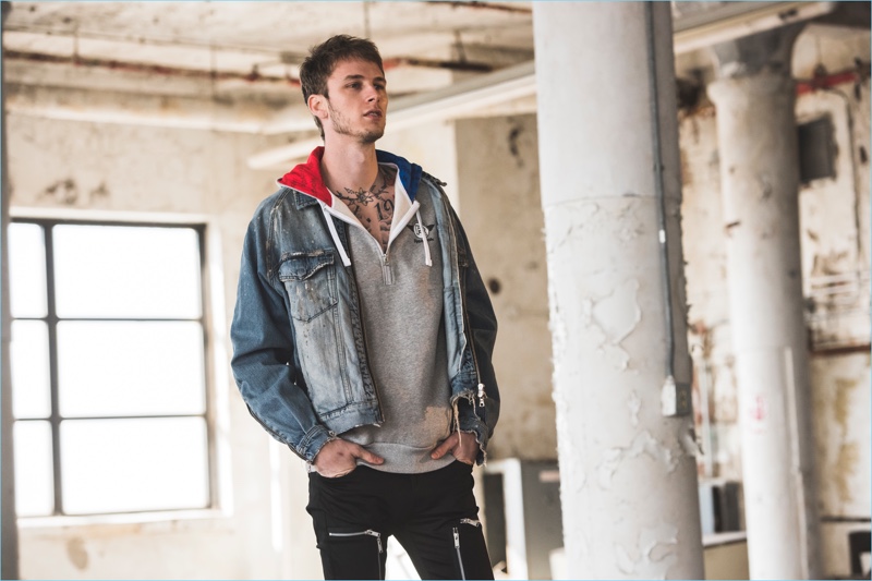 Wearing a denim jacket and hooded pullover, Machine Gun Kelly shoots his Reebok campaign.