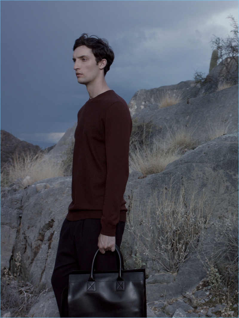 Max Von Isser wears a COS merino-wool sweater with relaxed crepe wool trousers. He also carries a COS leather tote bag.