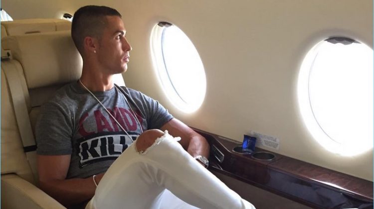 Traveling in luxury, Cristiano Ronaldo wears a pair of ripped white denim jeans from his CR7 range.