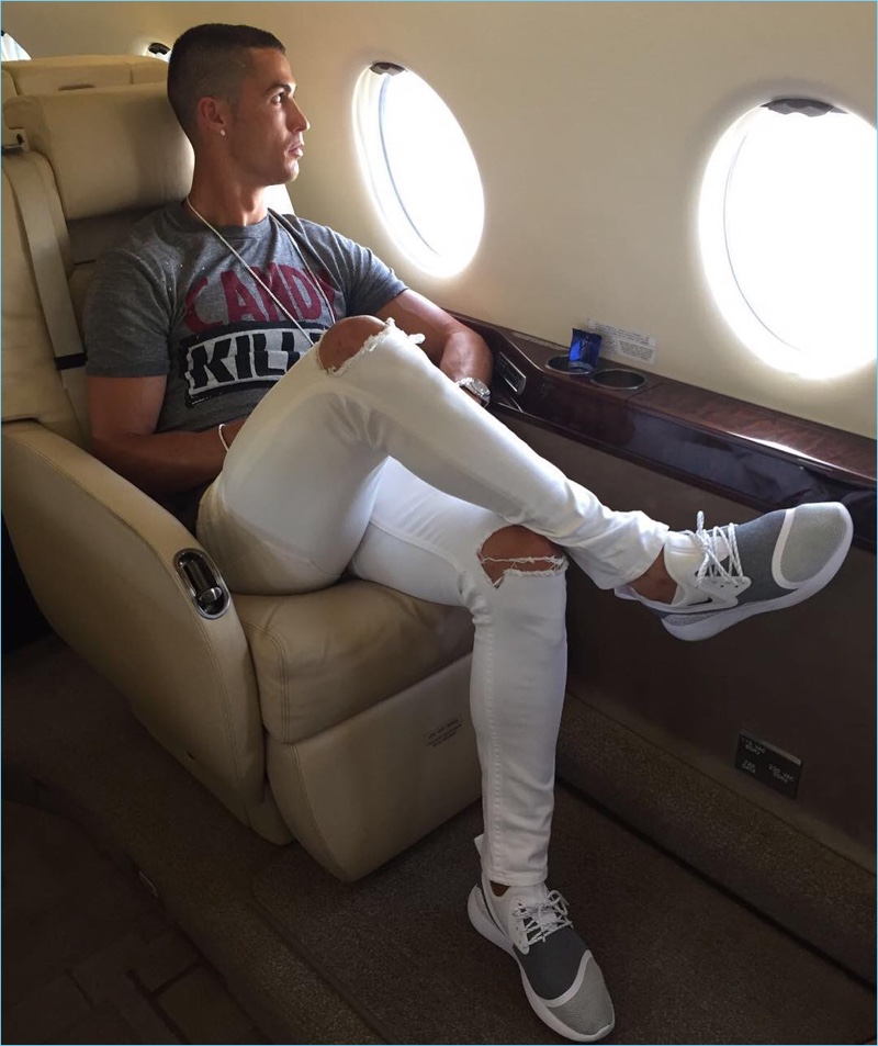 Traveling in luxury, Cristiano Ronaldo wears a pair of ripped white denim jeans from his CR7 range.