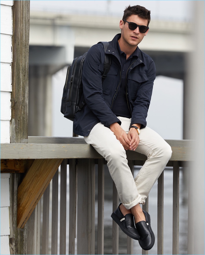 It's About Timeless: Miles Garber rocks a Theory field jacket $495 with a polo $70 by The White Briefs with J Brand slim-fit jeans $198. The model also wears a Tumi backpack $595, Bally slip-on sneakers $395, a Uniform Wares watch $600, and Le Specs sunglasses $69.