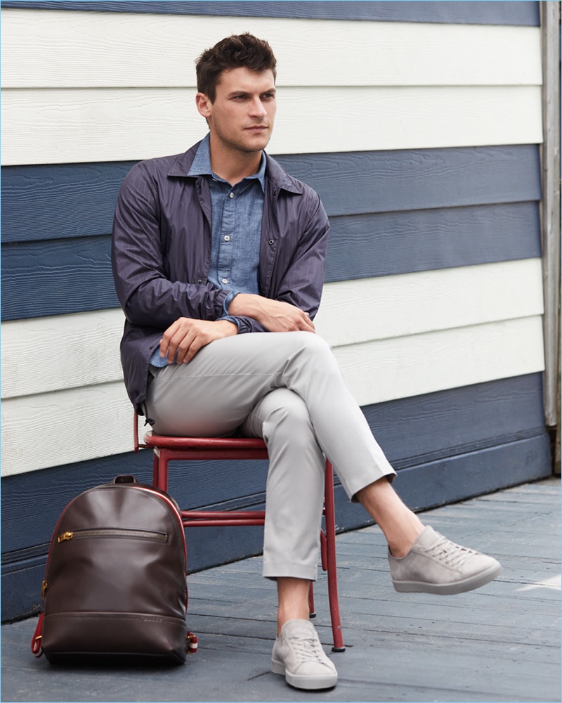 Relaxing, Miles Garber wears an Our Legacy chambray shirt $150 with a Theory pinstripe coach jacket $395 and cropped trousers $245. He also models a Jack Spade leather backpack $398 with To Boot New York suede sneakers $350.