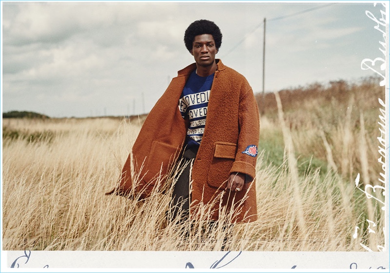 Embracing fall fashions, Josue Comoe wears an Off-White oversize coat. Underneath, he sports a Gucci "Loved" sweater with Marni trousers.