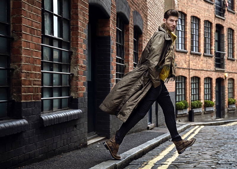 Ryan wears raincoat, sweater, and trousers Issey Miyake. He also rocks camouflage boots Dr Martens and scarf Spitalfield Market.