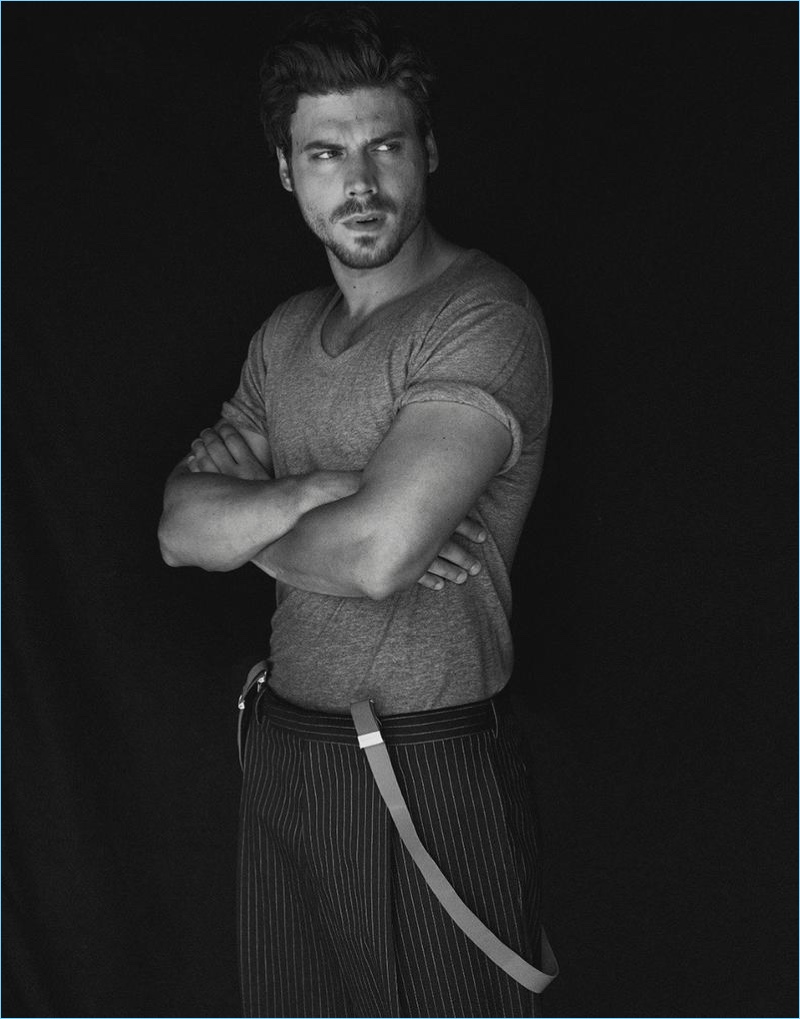 François Arnaud wears a T by Alexander Wang t-shirt with pinstripe Dior Homme trousers.