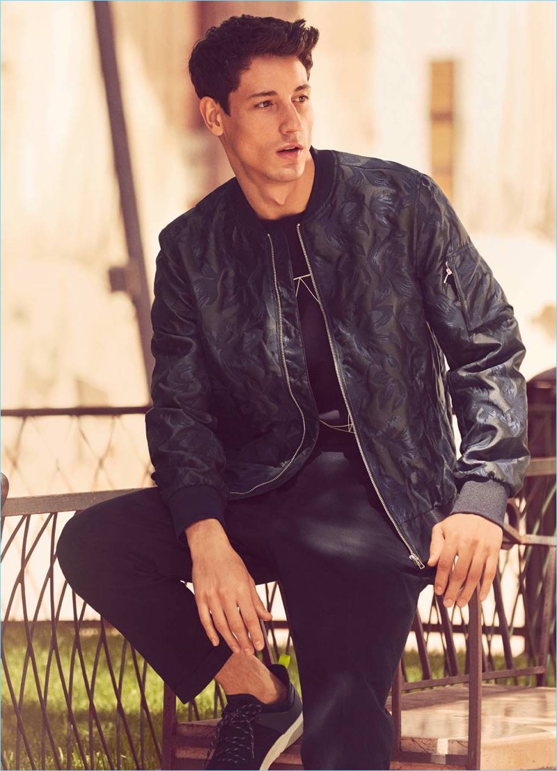 Stealing a quiet moment, Nicolas Ripoll wears a jacquard-weave bomber jacket $59.99 and a woven t-shirt $24.99. He also sports H&M seersucker pants $19.99 and form-stitched sneakers $49.99.