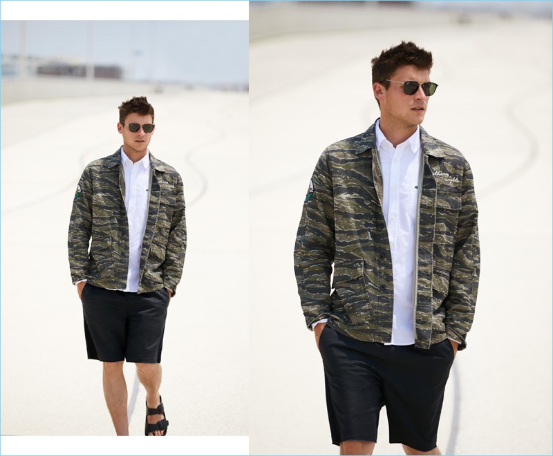 Solids collide with an easy print for this outfit. Miles Garber models a Current/Elliott camouflage jacket $278.60 with a Lacoste oxford shirt $98. He also wears RVCA shorts $45, Birkenstock sandals $35, and Ray-Ban sunglasses $150.