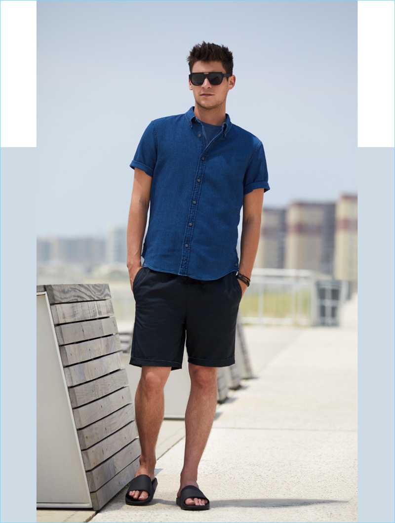 Standing by the smart button-down shirt, Miles Garber wears a short-sleeve shirt $98.50 by Club Monaco. He also dons a Vince tee $65, RVCA shorts $45, a Miansai bracelet $68, and Vince slide sandals $95.