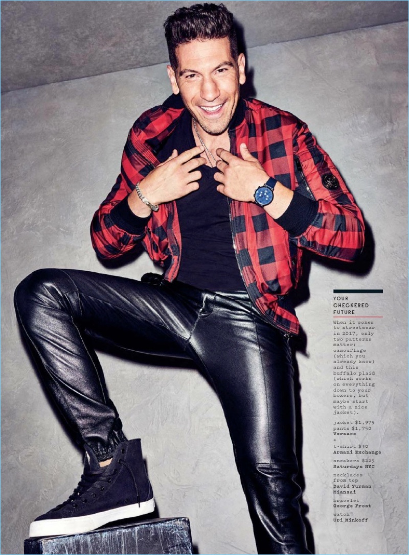 All smiles, Jon Bernthal wears a buffalo check jacket and leather pants by Versace. Bernthal also dons an Armani Exchange t-shirt and Saturdays NYC sneakers.