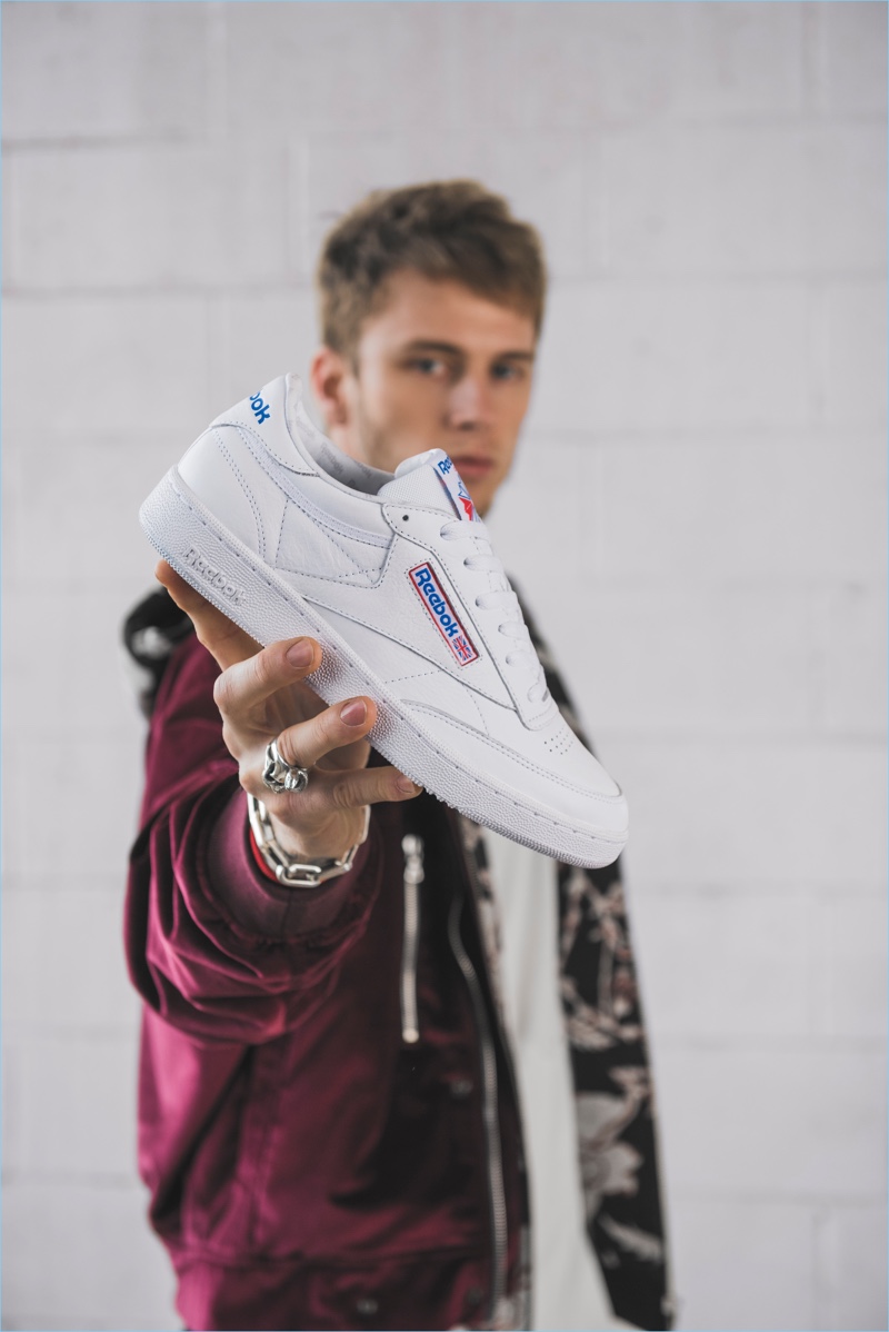 Starring in Reebok's new campaign, Machine Gun Kelly holds Reebok's Club C sneaker, which retails for $80.