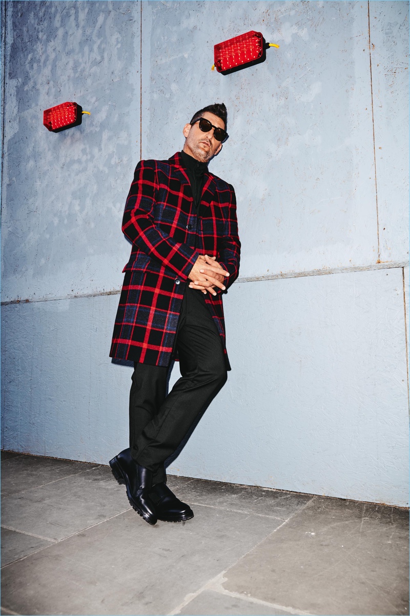 Making a graphic statement, Tony Ward wears a check coat by HUGO. The top model also sports Wormland pants and a half-zip HUGO pullover.