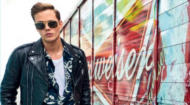 A cool vision, Bill Skarsgård wears a Matania leather biker jacket with a Saint Laurent shirt. Skarsgård also sports a Calvin Klein tank and Barton Perreira sunglasses with trousers and accessories by Salvatore Ferragamo.