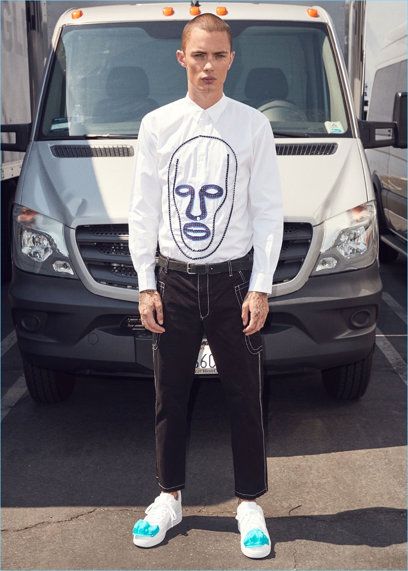 Embracing a black and white look, Simon Kotyk wears a Comme des Garçons Shirt cotton poplin shirt $487 with drill pants $528. Simon's look is complete with Comme des Garçons Homme Plus sneakers $374.