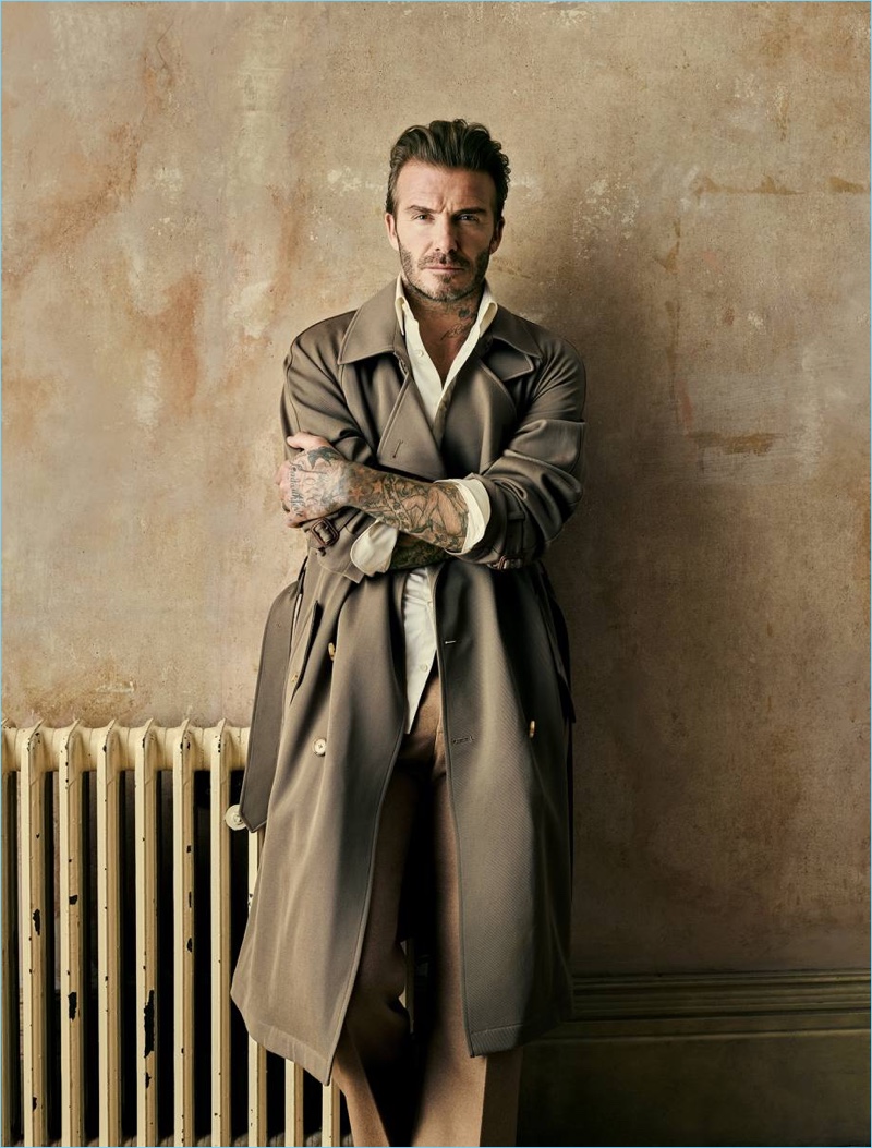 Crossing his arms, David Beckham wears a Ralph Lauren Purple Label silk trench coat with an Alexander McQueen shirt and trousers.