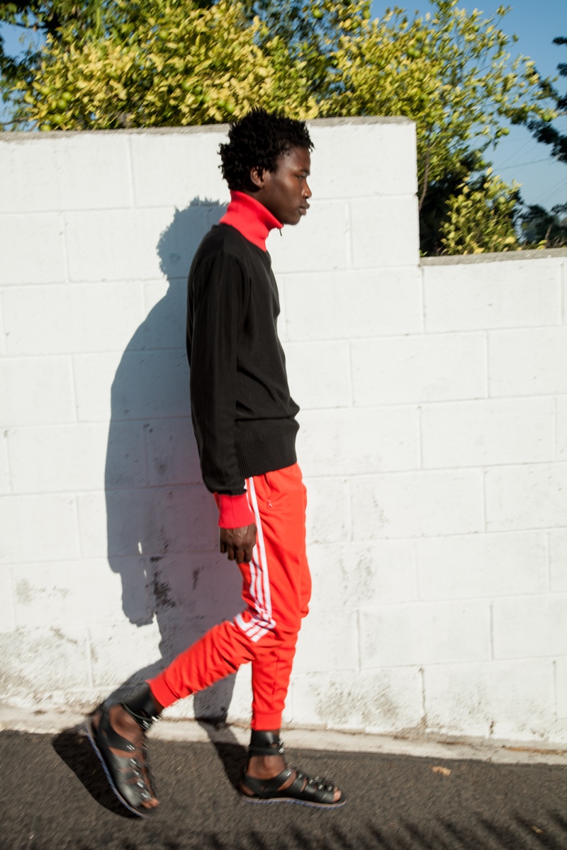 Cheikh wears sweater AMI, pants Adidas, and sandals Vivienne Westwood.
