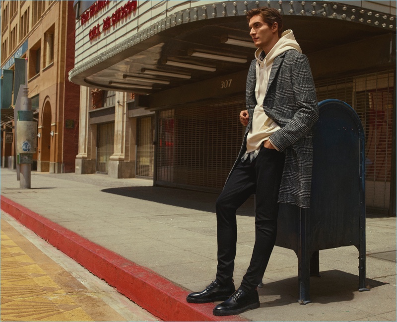 Layering for fall, Matvey Lykov wears a check coat with a hoodie for H&M's fall 2017 campaign.