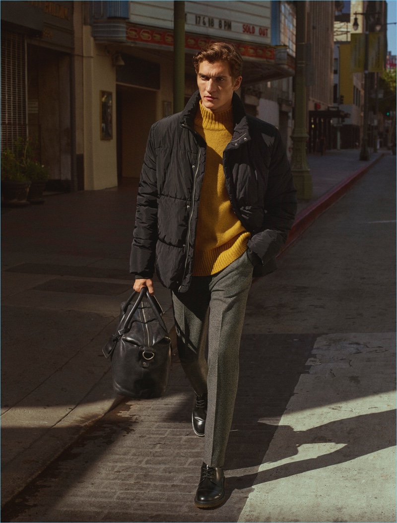 Embracing a pop of color, Matvey Lykov wears a mustard yellow sweater with a quilted jacket and pleated trousers by H&M.