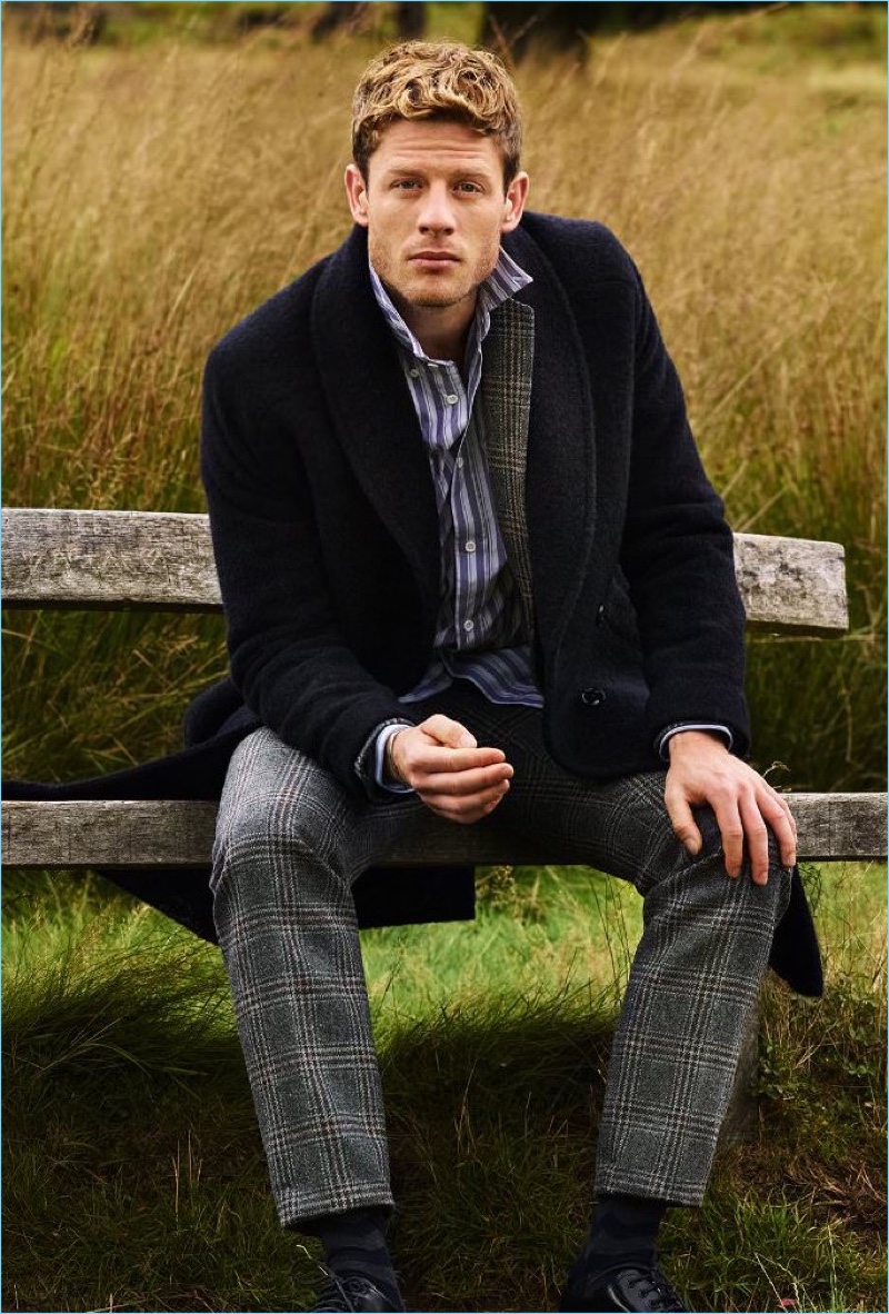 Making a case for smart fall style, James Norton wears a MP Massimo Piombo coat with a Dries Van Noten tweed blazer. Sitting outside, Norton also sports an Acne Studios shirt, Dries Van Noten trousers, and Prada derby shoes.