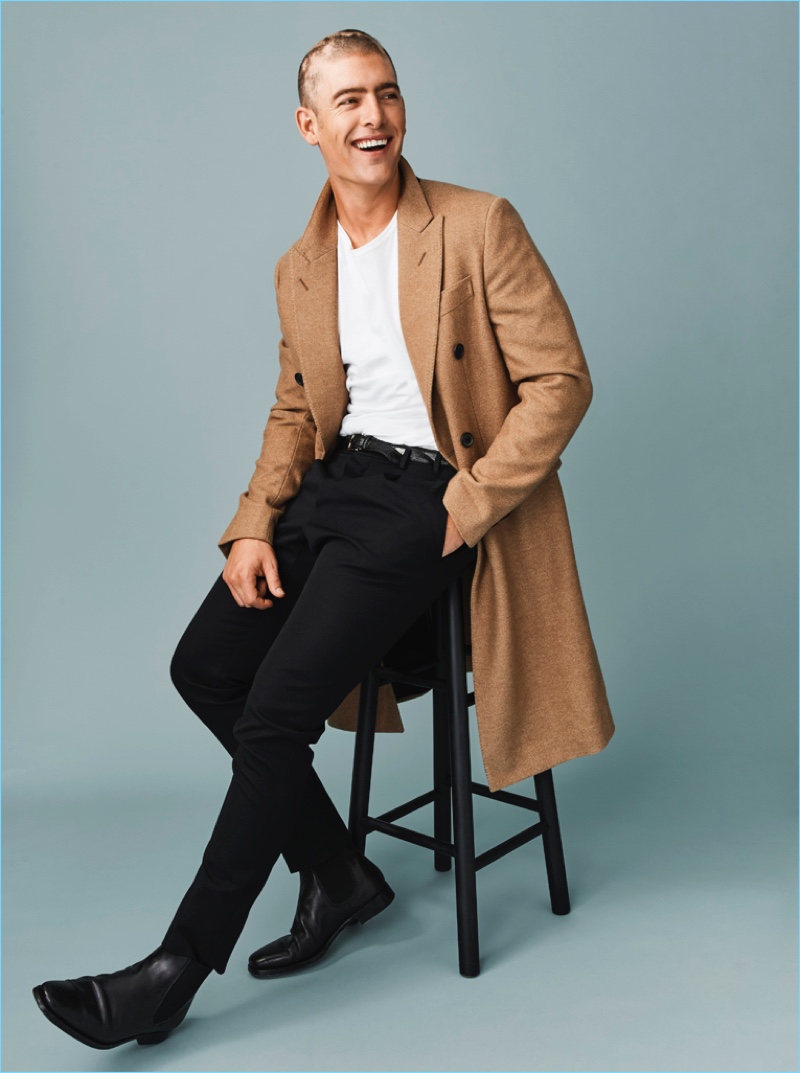 Model Justin Hopwood wears a camel coat and other essentials from Berluti.