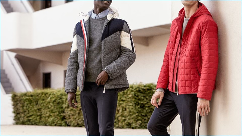 Stay warm and comfortable with these down jackets. Left to Right: Moncler Gamme Bleu hooded down jacket, Thom Browne sweater, Officine Generale oxford shirt, and Valentino trousers. Prada padded zip-up nylon jacket, Acne Studios sweatshirt, and Valentino trousers.