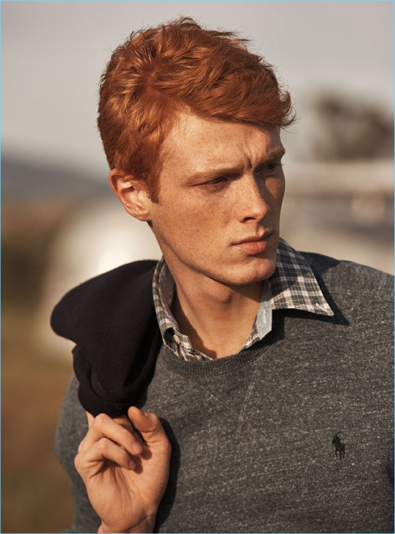 Linus Wordemann models a crewneck logo sweater from POLO Ralph Lauren with a smart button-down shirt.