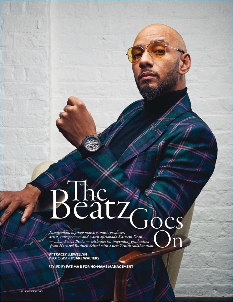 Connecting with Revolution, Swizz Beatz dons a double-breasted tartan suit by Bally. He also sports a John Smedley turtleneck, Grey Ant sunglasses, and a Zenith watch.