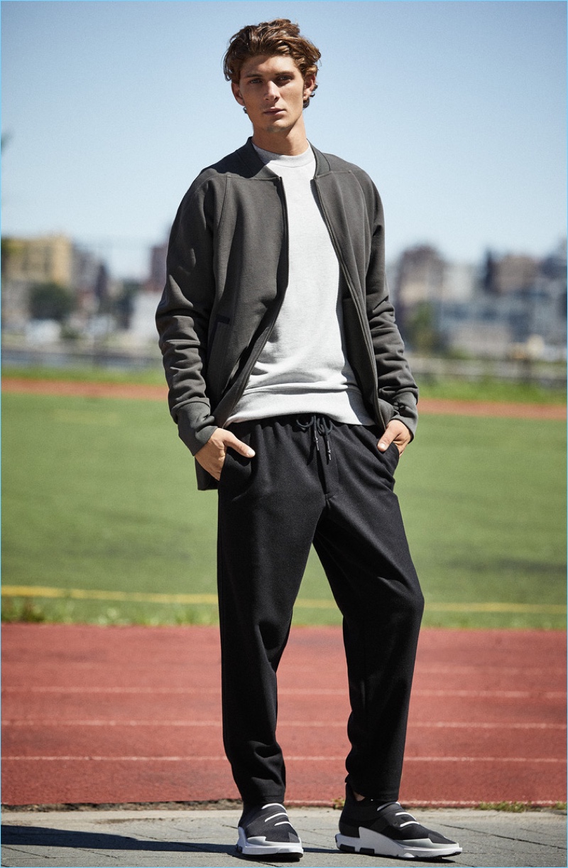 Front and center, Jake Lahrman sports a Y-3 classic sweatshirt $180, bomber sweatshirt $390, Noci low sneakers $390, and tube pants $390.