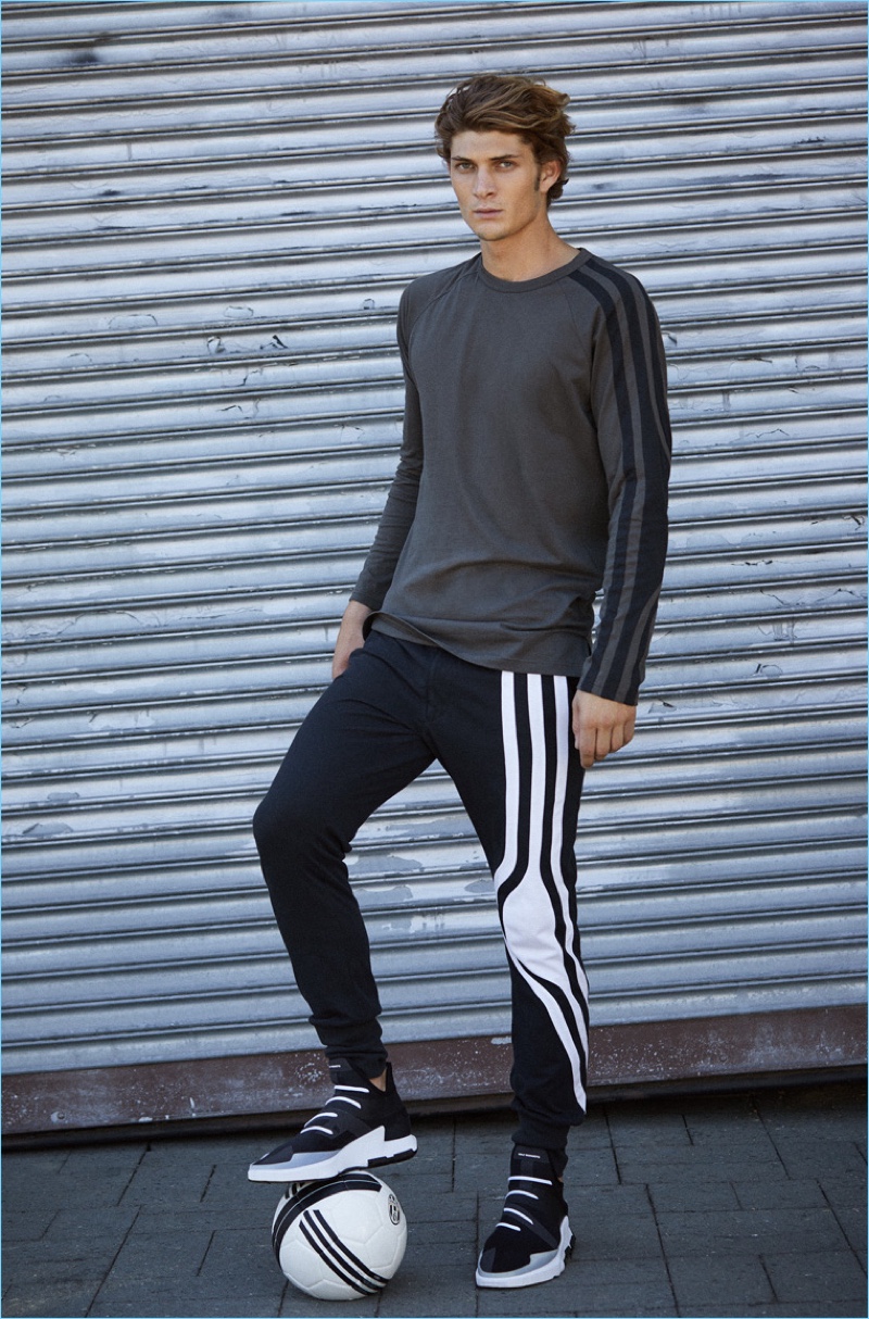 A sporty vision, Jake Lahrman models a Y-3 long-sleeve tee $160, stripes long johns $200, and Noci low sneakers $390.