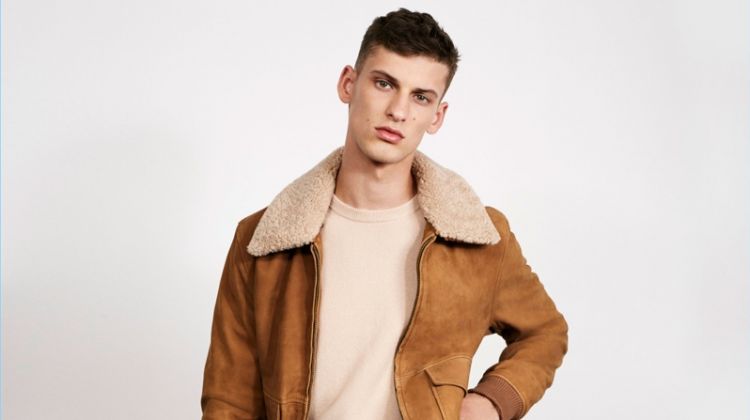 Zara Man makes a case for fall neutrals. Front and center, model David Trulik wears a camel hued aviator jacket with pleated trousers and a crewneck sweater.