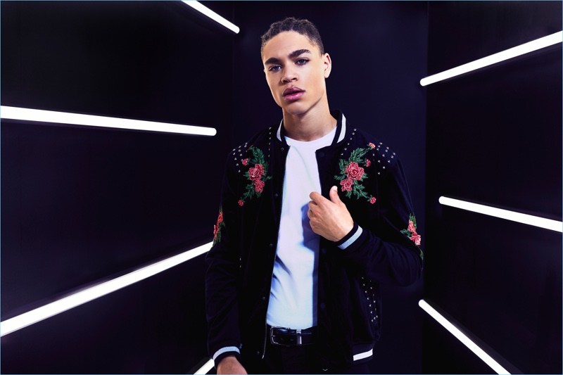 Model Brian Whittaker sports a boohooMAN premium rose embroidered bomber jacket.