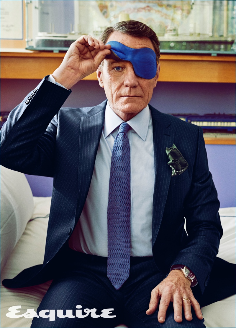 Actor Bryan Cranston wears a BOSS pinstripe suit with a shirt and pocket square by Charvet. He also wears a Belvest tie.