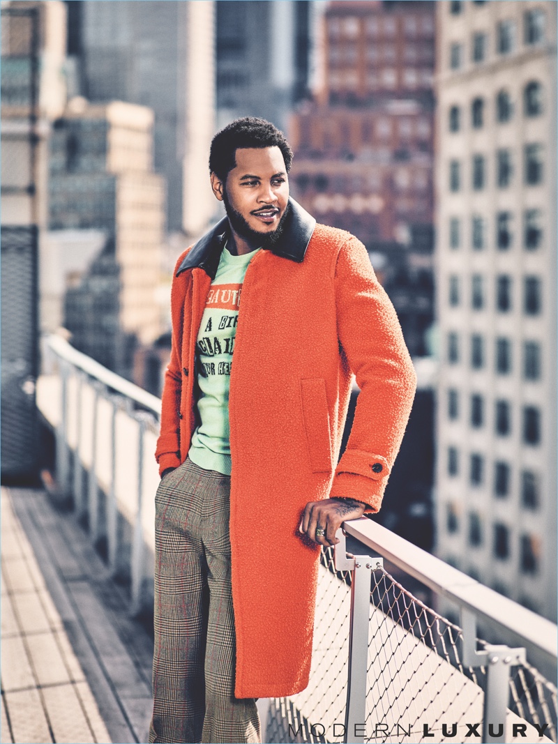 Connecting with Gotham, Carmelo Anthony wears a Valentino sweater and coat. He also dons Gucci trousers.