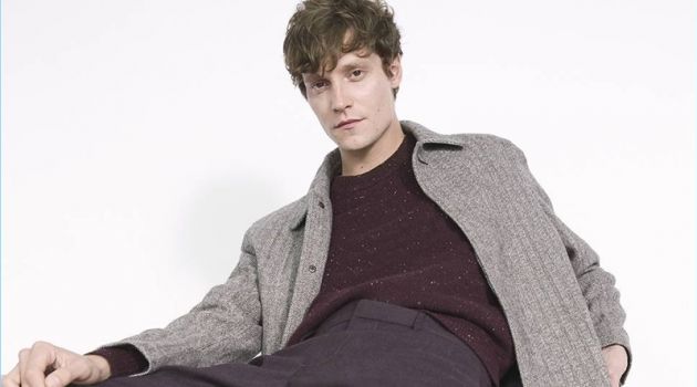 Relaxing, Matthew Hitt wears a Club Monaco herringbone coat with a sweater and dress pants.