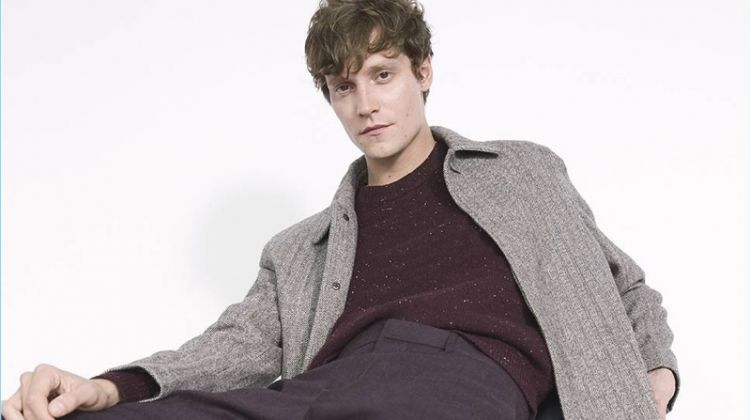 Relaxing, Matthew Hitt wears a Club Monaco herringbone coat with a sweater and dress pants.