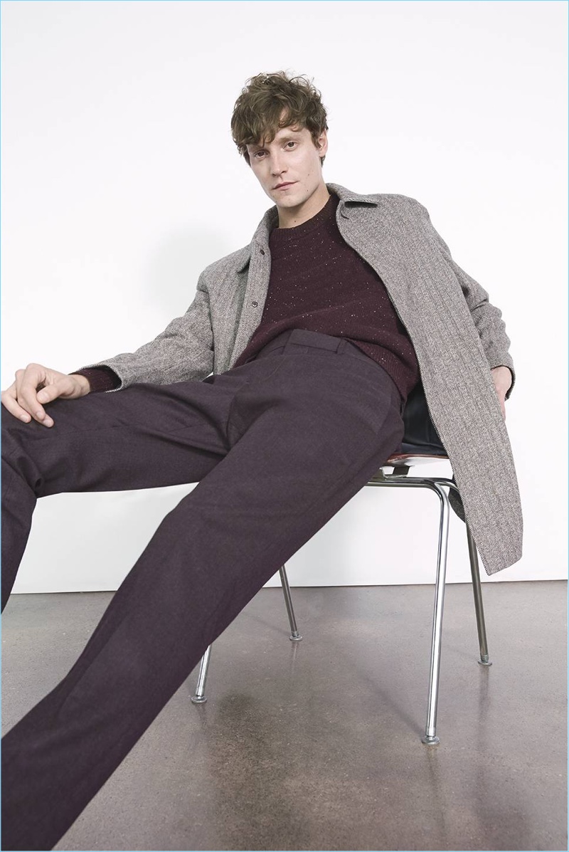 Relaxing, Matthew Hitt wears a Club Monaco herringbone coat with a sweater and dress pants.