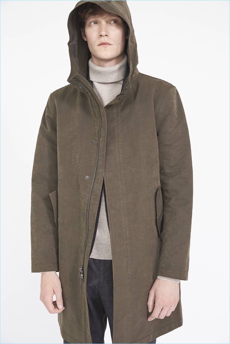 English model Matthew Hitt wears a Club Monaco cashmere turtleneck and hooded tech mac coat. He also dons herringbone trousers.