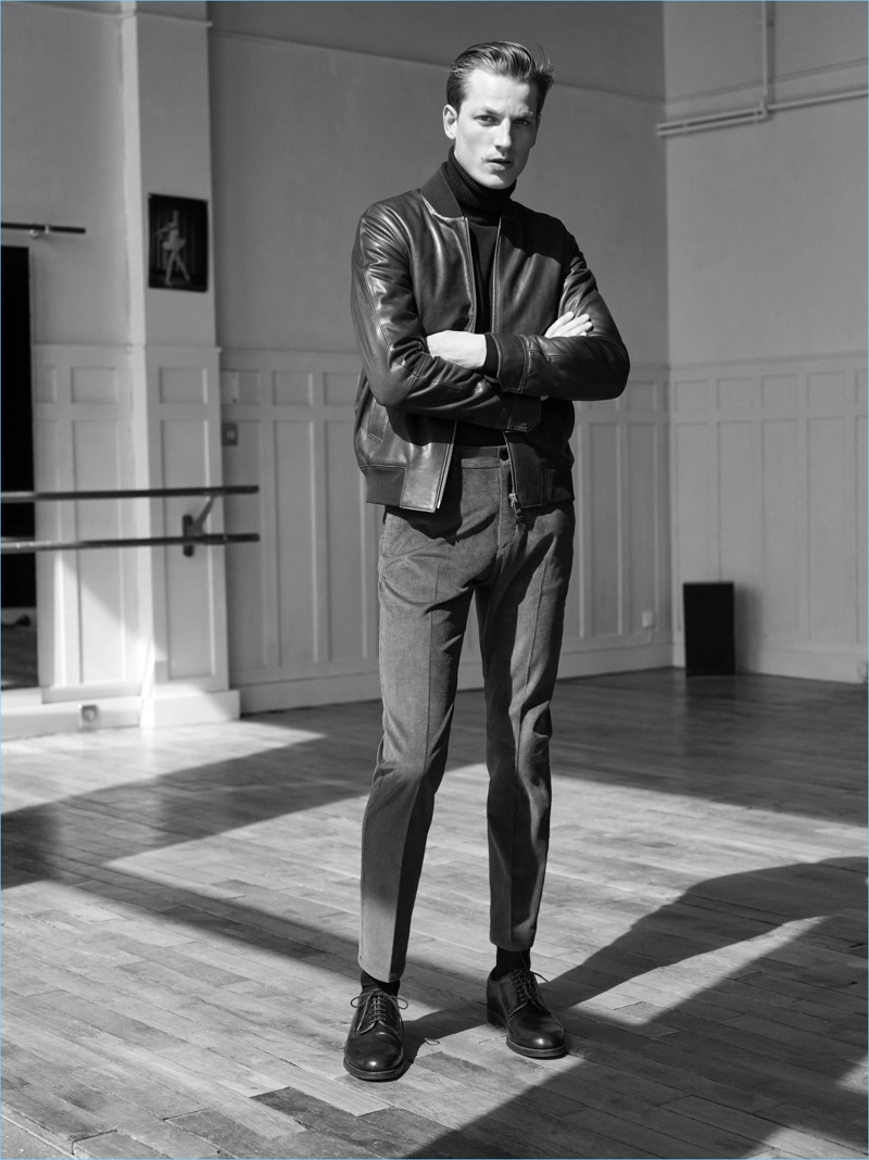 A sleek vision, Hugo Sauzay wears a leather jacket with a turtleneck and pleated trousers by De Fursac.