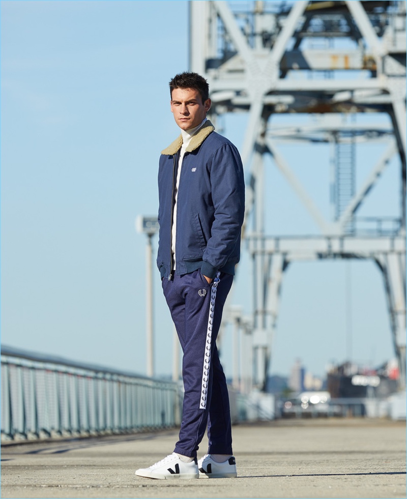 Get Sporty: Reuniting with East Dane, Miles Garber rocks an Obey jacket with Fred Perry track pants. Miles' look is complete with an A.P.C. mock neck sweater and Veja sneakers.