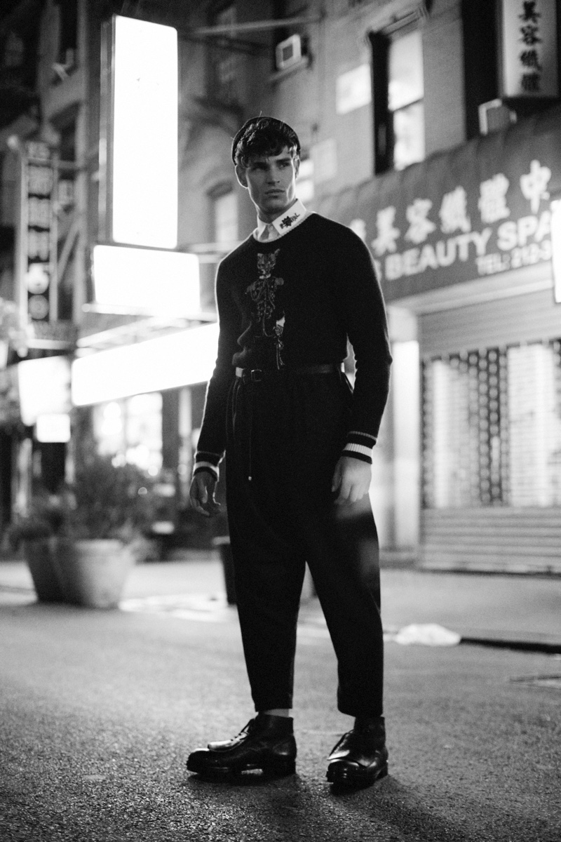 Louren wears trousers Issey Miyake, hat Marc Jacobs, shoes Hugo Boss, shirt, belt, and sweater Dolce & Gabbana.