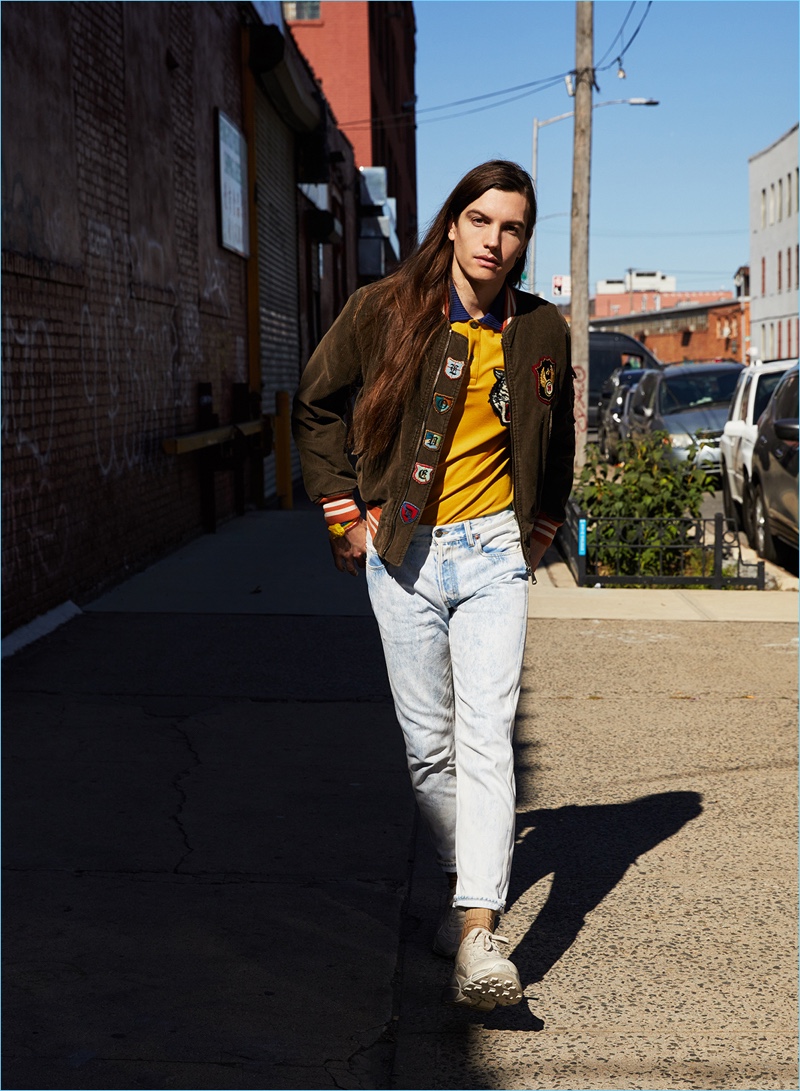 Taking a stroll, Ian Mellencamp wears a Gucci corduroy bomber jacket, tiger face polo shirt, acid washed jeans, and leather sneakers.