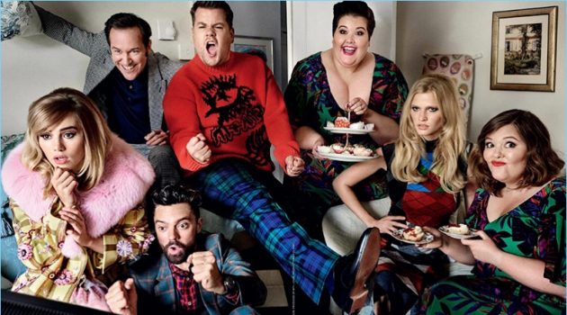 Actors Bertie Carvel and Dominic Cooper watch television with James Corden. Corden's sisters as well as models also appear in the image. Carvel wears a Turnbull & Asser suit with a John Smedley shirt. Cooper dons a Paul Smith suit and shirt. Finally, Corden rocks a Stella McCartney sweater.
