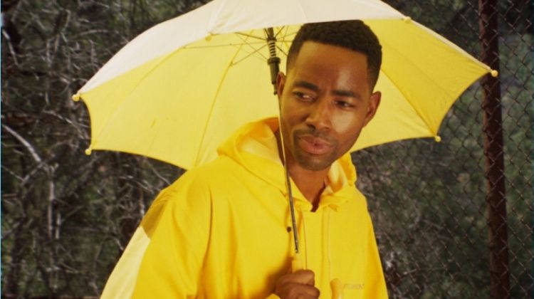 Dressed in yellow, Jay Ellis wears a Vetements raincoat.