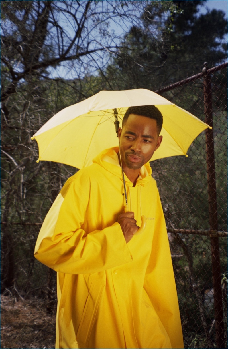 Dressed in yellow, Jay Ellis wears a Vetements raincoat.