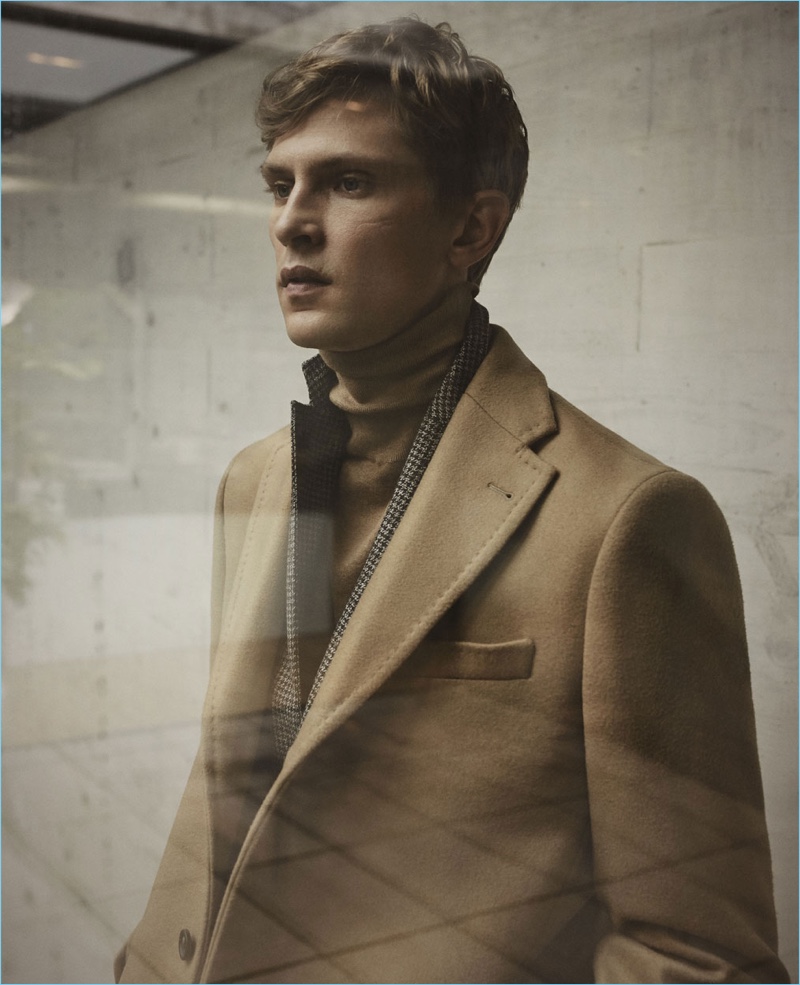 Embracing fall styles, Mathias Lauridsen wears a camel coat with a houndstooth blazer and turtleneck by Massimo Dutti.