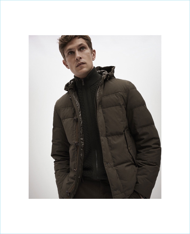 Model Mathias Lauridsen dons a Massimo Dutti down puffer jacket with a textured cardigan sweater.