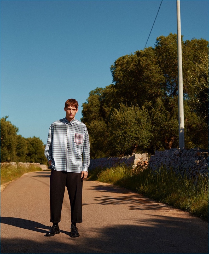 Stepping outside, Baptiste Radufe wears a shirt by Comme des Garçons Shirt with Craig Green trousers and Alexander McQueen shoes.