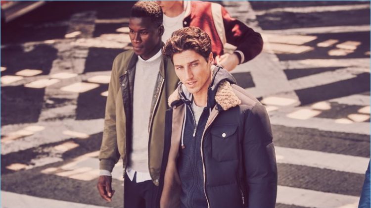 Left: David Agbodji rocks an Engineered Garments bomber jacket, Thom Browne sweatshirt, and Acne Studios shirt. The top model also dons Wooyoungmi sweatpants. Right: Ryan Kennedy wears a Brunello Cucinelli shearling-trimmed quilted shell jacket and zip-up hoodie. He also sports a Tom Ford t-shirt.