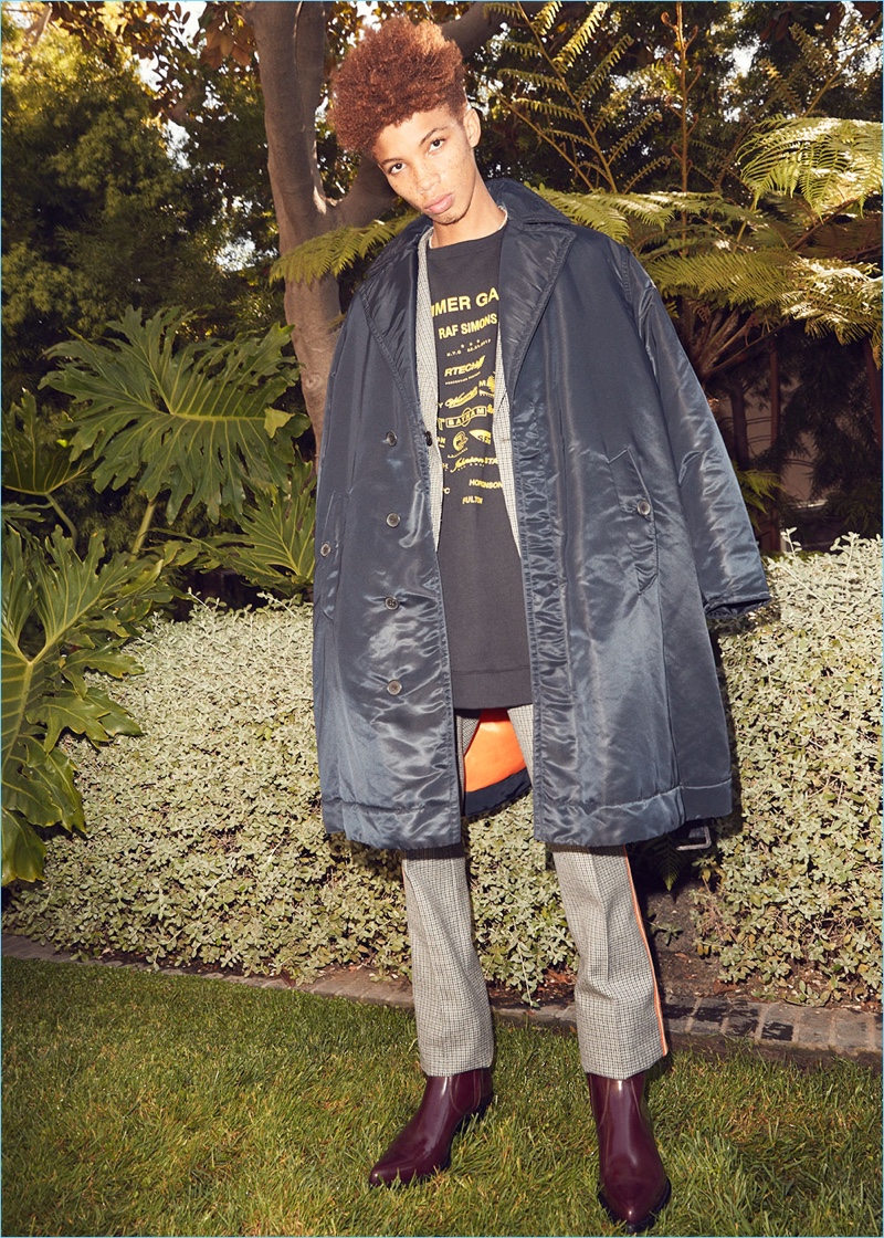 A Calvin Klein 205W39NYC satin jacket represents Raf Simons' modern style. Here, Tay Godsey wears it with a suit and western boots by the brand. Raf Simons' oversize sweatshirt completes Tay's look.