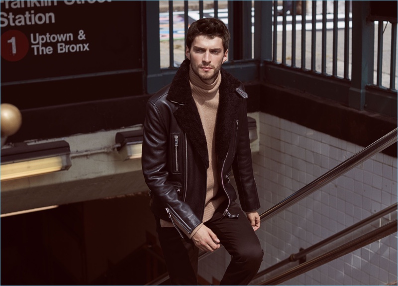 Chic meets cool as Matthew Bell models a Reiss shearling collar biker jacket $1,120. The statement piece pairs well with a camel turtleneck sweater $240 and slim-fit chinos $210.